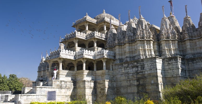 Exterior view of the white marble Dilwara Jain Temple with carved pillars and domes in Mount Abu