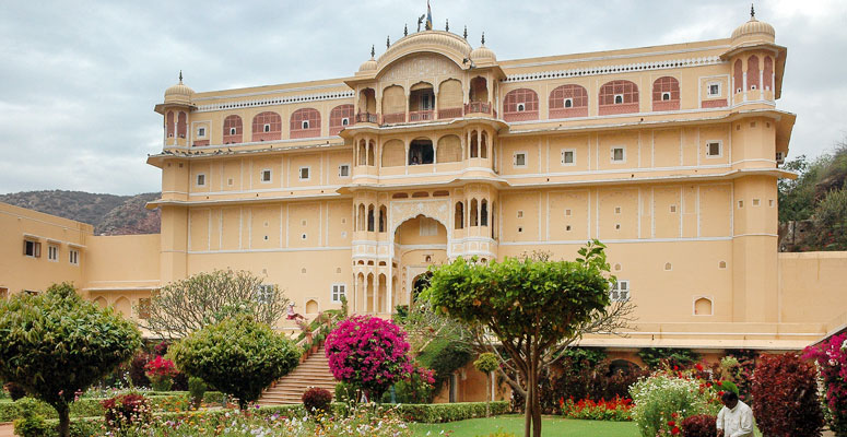 Exterior view of Samode Palace with grand arches, frescoed balconies, and landscaped gardens in Rajasthan