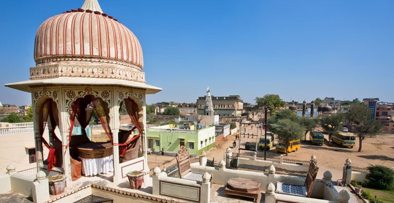 Courtyard view of Raghunath Ji Temple in Mandawa featuring traditional Rajasthani architecture and stone rooftop terraces