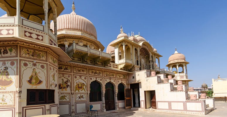 Exterior of Castle Mandawa Fort featuring ornate domes, carved archways, and traditional painted frescoes in Shekhawati, Rajasthan
