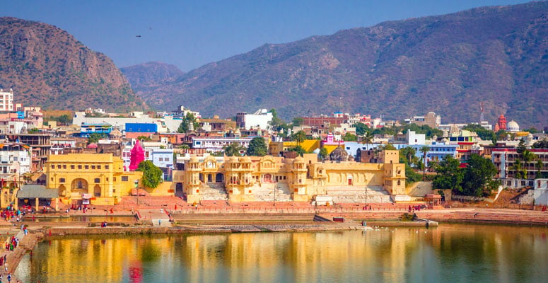 Devotees and tourists at the holy Pushkar Lake ghats in Rajasthan surrounded by heritage architecture
